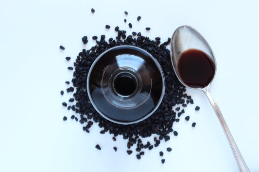Spoon of Elderberry Syrup with Glass and Elderberries